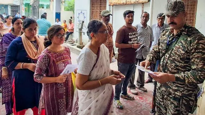 Voters-stand-in-que-to-vote-in-the-2026-West-Bengal-Assembly-election.webp